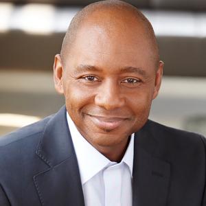 Branford Marsalis smiling in a light button shirt and dark j