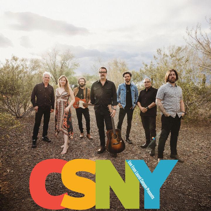 Members of Live From Laurel Canyon outside on a dirt road with the logo CSNY superimposed under their feet.