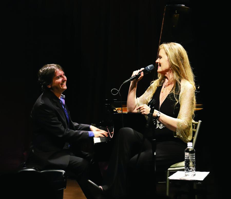 Tierney Sutton and Tamir Hendelman performing together on a dark stage